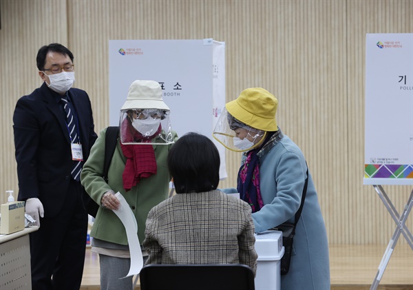 '소중한 한 표 행사' 제21대 국회의원 선거 사전투표 첫날인 10일 오전 서울 종로구 가회동 주민센터에서 비닐모자와 마스크를 한 주민이 사전투표를 하고 있다. 제21대 국회의원 선거 사전투표는 10∼11일 이틀간 전국 3천508개 투표소에서 진행된다.