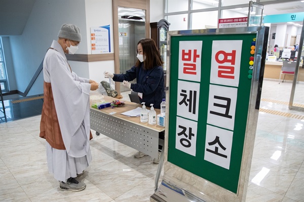 사전투표소에서 발열 체크를 하고 있는 법륜스님 코로나19로 전국 사전투표소 입구에는 발열체크가 이뤄지고 있다. 울산광역시 울주군 두서면 사전투표소의 모습.  