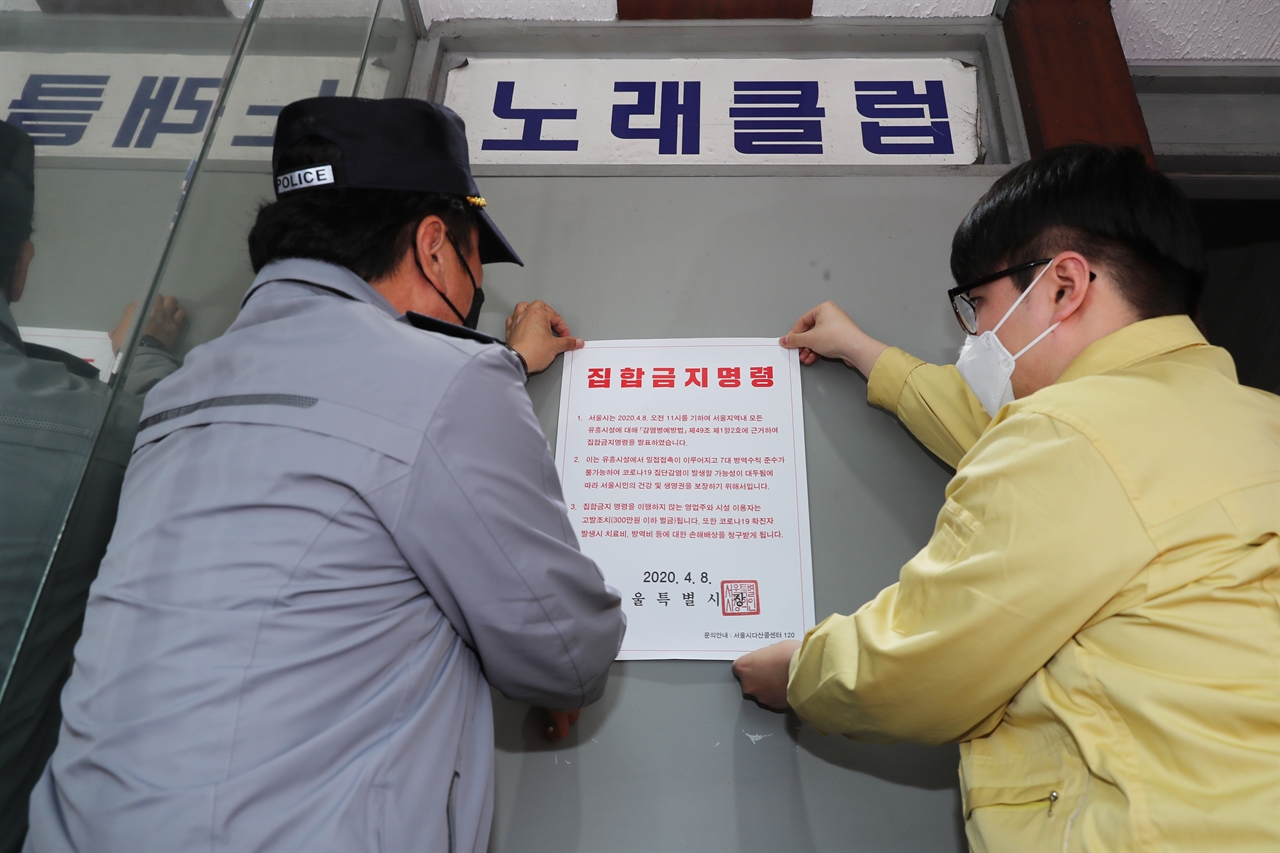 9일 성동구 보건소 관계자와 경찰이 서울 성동구의 한 유흥업소에 집합금지 명령서를 붙이고 있다.
