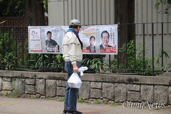 대구 수성구 지산1동 사전투표소 앞에서 한 유권자가 사전투표에 앞서 선거벽보를 바라보고 있다.