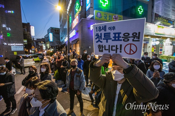 13일 오후 서울 종로구 평창동에서 한 시민이 18세 투표자들을 격려하는 피켓을 들고 있다.