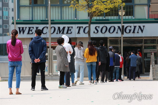 21대 총선 투표일인 15일 오전 서울 성북구 숭인초등학교에서 '코로나19' 감염예방을 위해 마스크를 쓴 유권자들이 투표를 하기 위해 운동장에 길게 줄을 서 있다.