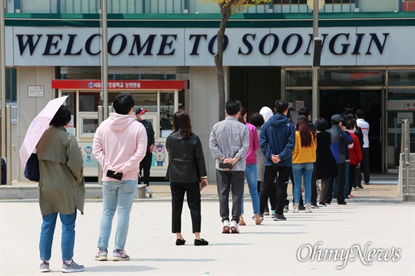 21대 총선 투표일인  4월 15일 오전 서울 성북구 숭인초등학교에서 '코로나19' 감염예방을 위해 마스크를 쓴 유권자들이 투표를 하기 위해 운동장에 길게 줄을 서 있다.
