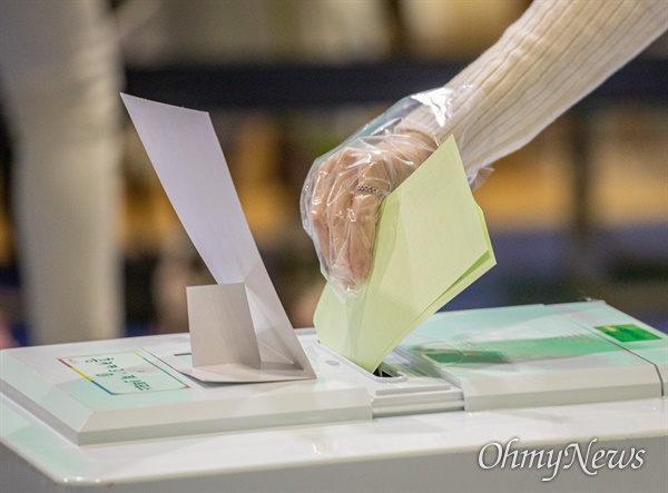 21대 총선 투표일인 2020년 4월 15일 오전 서울 서대문구 홍제배드민턴장에 마련된 홍제 제3동 제3투표소에서 한 시민이 비닐장갑을 끼고  투표를 하고 있다.