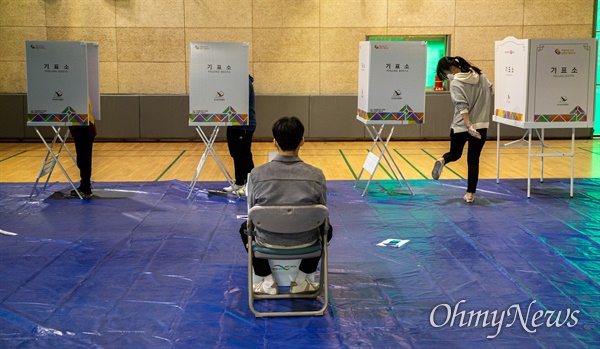 제 21대 총선 투표일인 지난 15일 오전 서울 서대문구 홍제배드민턴장에 마련된 홍제 제3동 제3투표소에서 시민들이 마스크를 쓰고  투표를 하고 있다. 