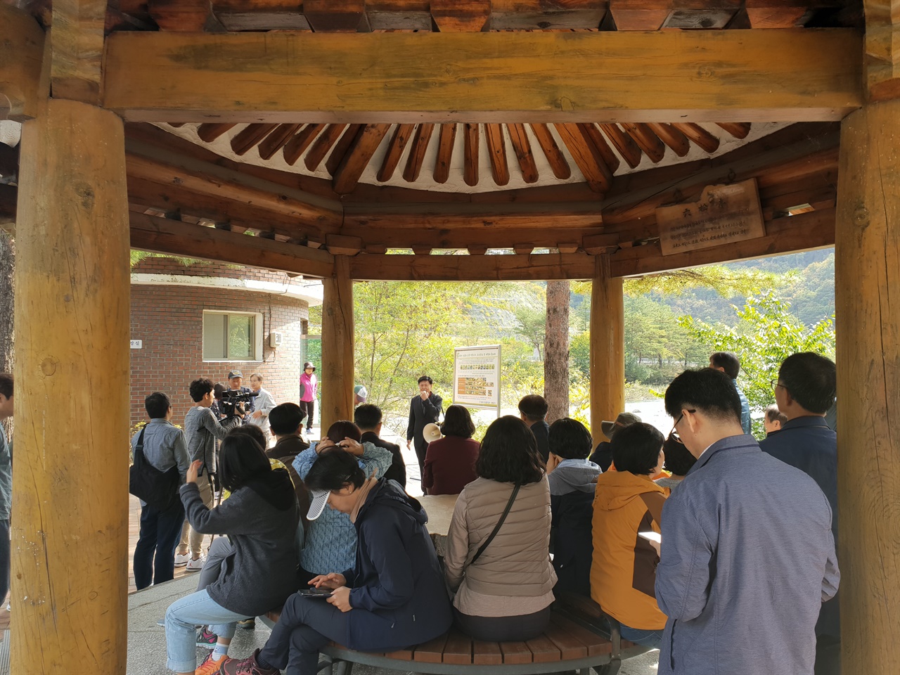 영풍제련소 시민탐방단이 육송정삼거리에 있는 정자에 모여 있다. 나그네의 휴식공간으로 이용되는 정자 안쪽에는 육송정의 유래를 적은 현판이 걸려 있다.