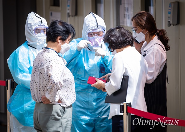 지난 5월 11일 오후 서울 용산구 이태원 인근 대형병원에서 코로나19 검사를 받기 위해 줄을 선 대기자들 사이에서 의료진이 검사 안내를 하고 있다. 