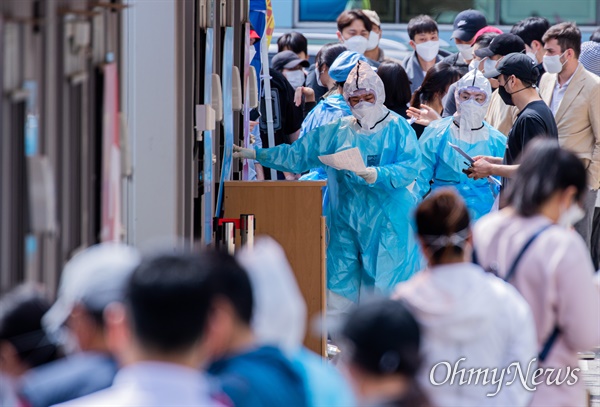 이태원 한  클럽에서 코로나19 확진자가 다녀가 확진자  증가하자 11일 오후 서울 용산구 이태원 인근 대형병원에서 코로나19 검사를 받기 위해 줄을 선 대기자들 사이에서 의료진이 검사 안내를 하고 있다. 