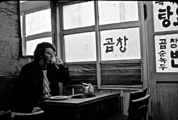 평화봉사단 자격으로 1971년~1974년 광주에 머물렀던 도널드 베이커의 모습이 담긴 사진. 1972년 '곱창'이라고 적힌 가게에서 막걸리를 마시고 있는 모습이다.