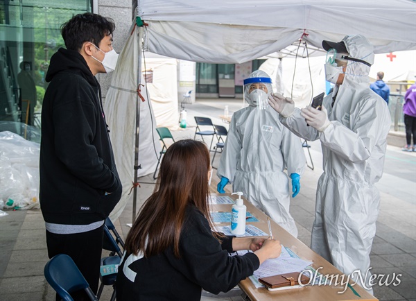 12일 오후 서울 용산구 보건소에 코로나19 검사를 받기 위해 마스크를 쓴 시민들이 사회적거리를 유지하며 대기하고 있다.