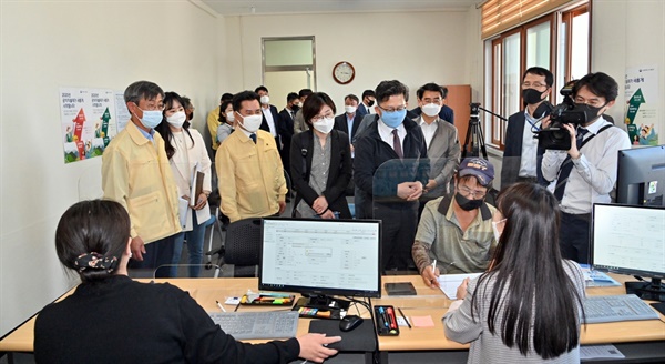 김현수(하늘색 마스크를 쓴) 농식품부 장관이 부여군 공익직불제 접수 현장에서 한 신청자의 공익직불제 신청 과정을 보고 있다. 