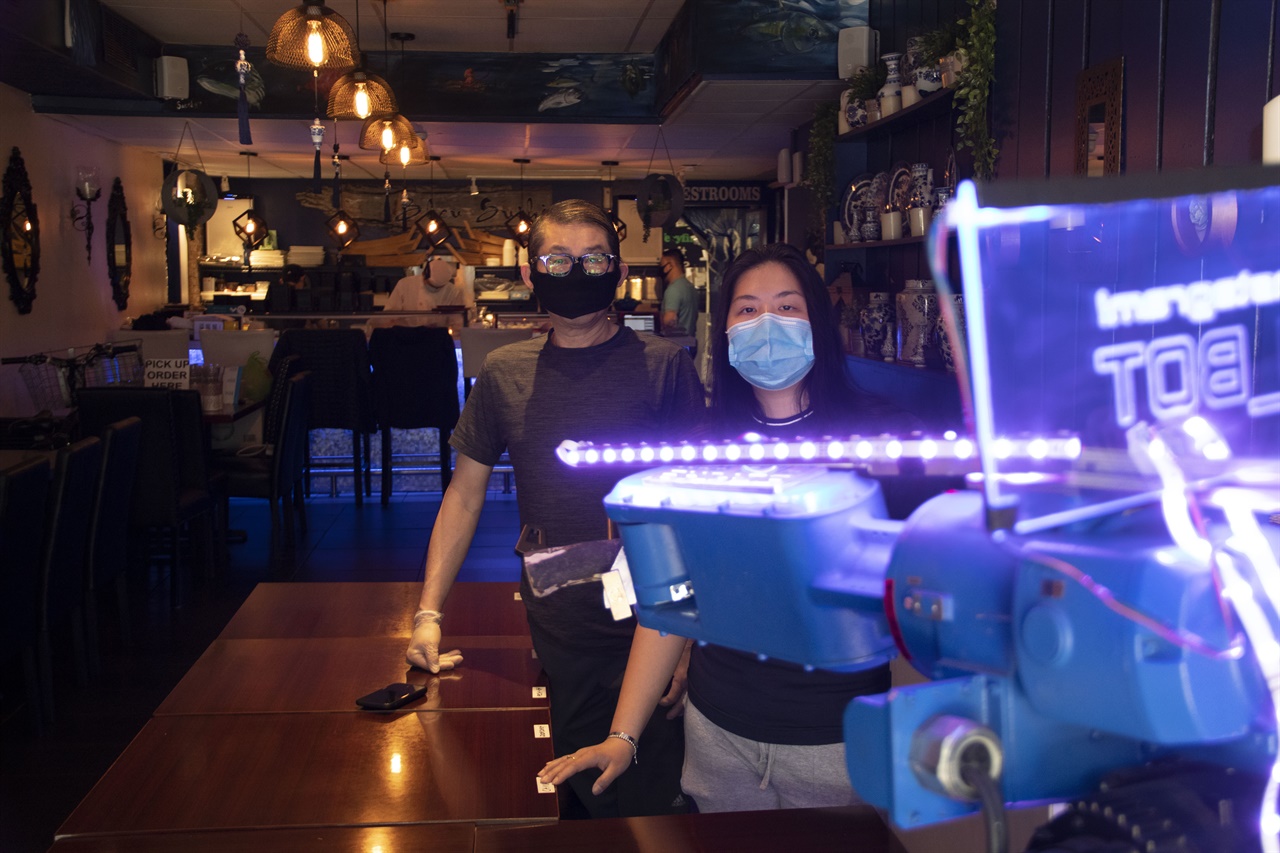 로봇 앞에서 식당 고객서비스를 하고 있는 헨드라 용(Hendra Yong) 블루 스시 사장 부녀.