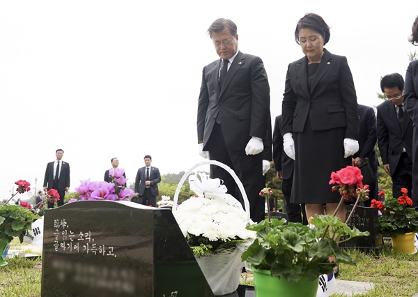 고 이연씨 묘 찾은 문 대통령 내외 문재인 대통령과 부인 김정숙 여사가 제40주년 5·18 민주화운동 기념일인 18일 광주 북구 5·18 민주묘지 제2묘역에서 고(故) 이연 씨 묘에 묵념하고 있다. 고인은 전남대 1학년에 재학 중이던 1980년 5월 27일 YMCA 회관에서 계엄군과 총격전 중 체포되어 전신 구타를 당했다.