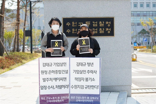 김태규 님의 어머님과 누나가 수원고등검찰청 앞에서 엄정 수사, 처벌을 요구하는 피켓을 들고 있습니다. 