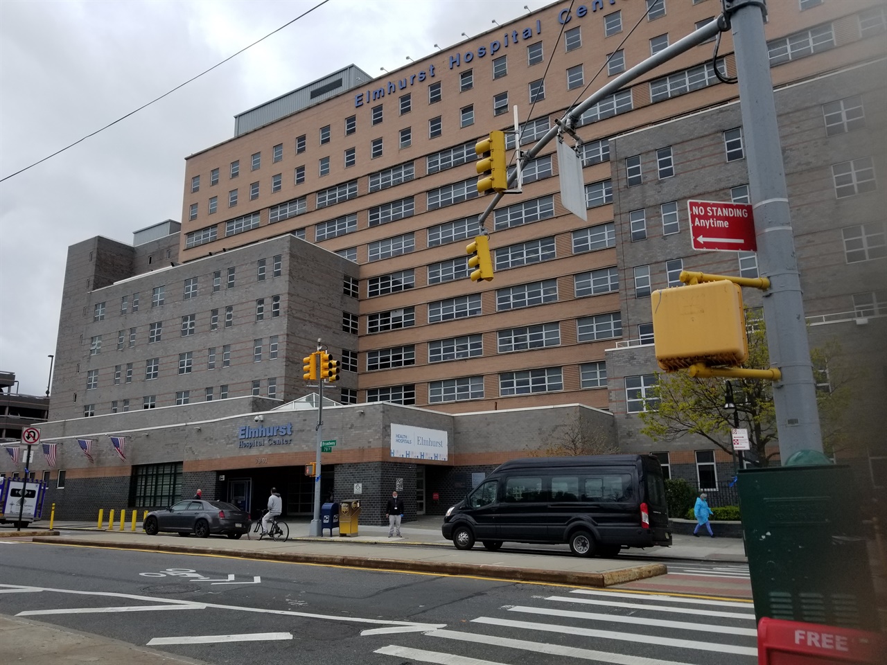 뉴욕시 퀸즈에 있는 이 병원에서 코로나19 가 한창 강세였던 때는 하루에 13명이나 사망자가 발생한 적도 있다. 서민 아파트가 많은 이 지역에는 코로나19 확진자가 유난히 많다. 자가격리 기간이라 길거리에는 차량이나 사람들이 별로 없다.