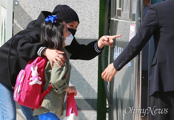 5월 27일 오전 서울 성북구 월곡초등학교에서 1,2학년 학생들이 코로나19 여파로 인해 미뤄진 등교를 시작하고 있다. 엄마가 학생을 교실로 들여보내며 이야기를 하고 있다. 지난 20일 고3에 이어 27일에는 고2, 중3, 초1,2 학생들이 등교수업을 시작했다.