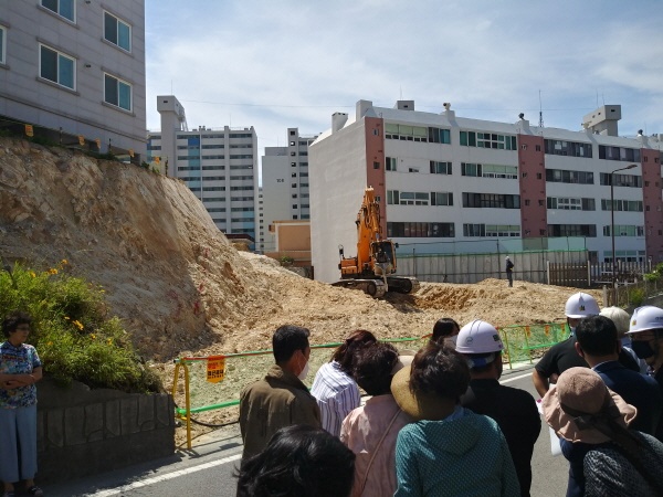 울산 동구청이 동구 남목시장 공영주차장 건립을 하면서 인근 남목원룸건물 언덕을 깍아내 주민들이 붕괴위험이 있다며 불안을 호소하고 있다. 27일 오전 10시 보는 사람이 아슬아슬한 공사현장에서 주민과 울산신문고위원. 동구청측, 시공사측이 입장을 밝히고 있다