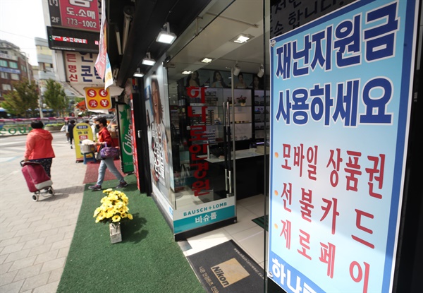 1차 전국민 재난지원금이 지급된 지난해 5월, 서울 중구 남대문시장 한 상점에 긴급재난지원금 사용 가능 안내문이 붙어 있다.