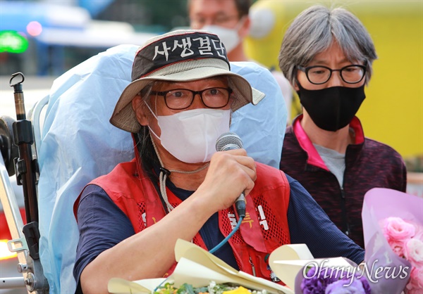 서울 강남역 네거리 삼성본관앞 25미터 CCTV탑에서 355일간 고공농성을 벌여왔던 삼성해고노동자 김용희씨가 29일 오후 삼성측과 합의를 하면서 농성을 종료했다. 고공농성을 종료하고 굴절사다리를 타고 내려온 김용희씨가 농성을 도와준 지지자들에게 인사하고 있다.