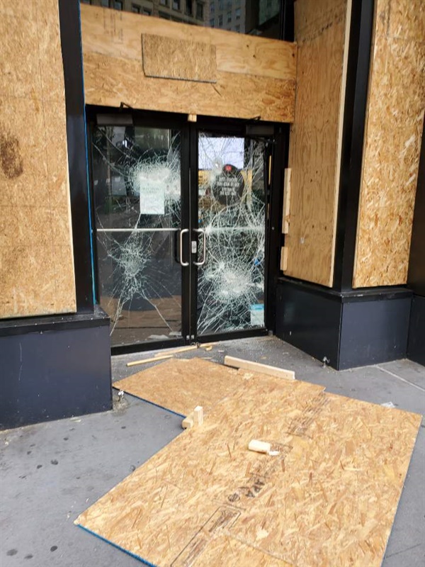 맨해튼의 한 상점이 약탈 파괴 행위를 막기 위해 널빤지로 창문과 출입구를 막고 있는 모습