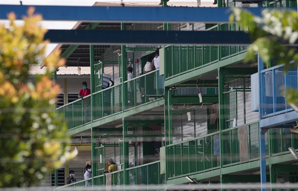 코로나19 확진자가 다수 발생해 격리지역으로 선포된 싱가포르의 한 이주노동자 기숙사에서 4월 21일 거주자들이 방에 머물지 않고 복도에 나와 있다.
