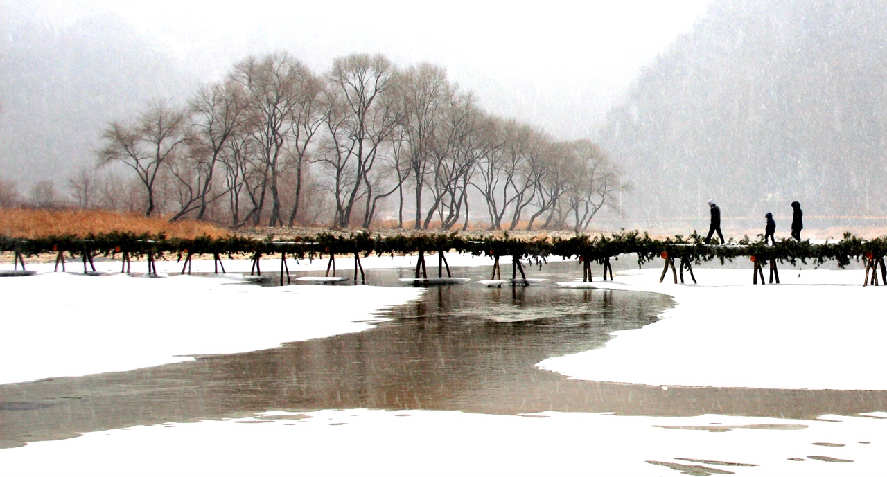 눈 내리는 겨울, 다리를 건너는 사람들. 눈보라가 날리는 강가, 섶다리를 건너 어딘가로 가고 있는 사람들.