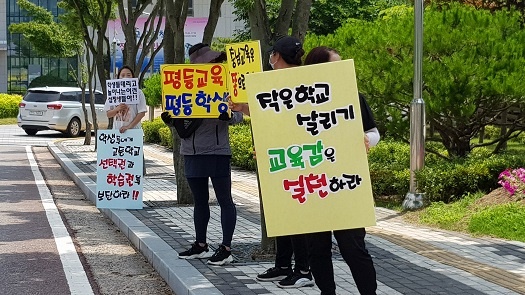 충남교육청 정문 앞에서 피켓을 들고 시위 중인 학부모들 