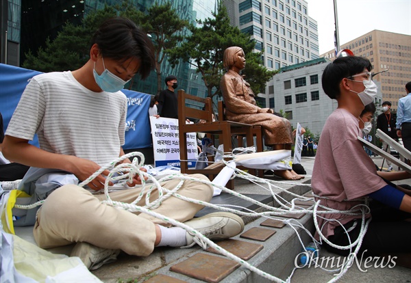 일부 보수단체들이 연일 수요시위 중단과 소녀상 철거를 요구하며 일본대사관앞 소녀상 주변에서 시위를 벌이는 가운데, 23일 오후 반아베반일청년학생공동행동 소속 대학생들이 서울 종로구 일본대사관앞 소녀상 주위에 앉아 끈으로 몸을 묶은 뒤 소녀상 지키기 연좌농성을 벌이고 있다.