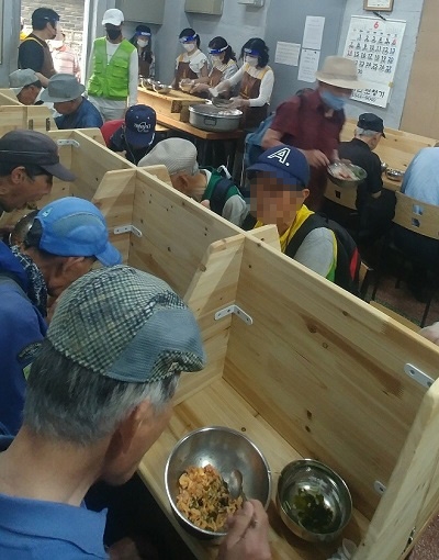 30일 점심식사를 하고 있는 노인들과 배식을 하고 있는 미디어헌터 탤런트 봉사단 회원들이다.