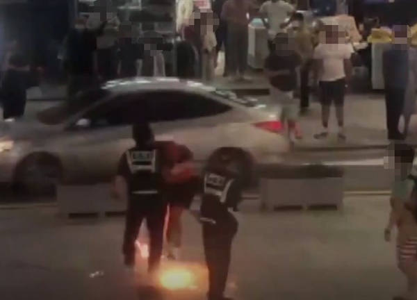  지난 4일 부산 해운대해수욕장 인근 구남로 광장에서 미군 등 외국인들이 미국의 독립기념일을 맞아 폭죽을 쏘고 있다. 한 미군이 경찰의 제지에도 바닥에 폭죽을 난사하고 있는 장면.