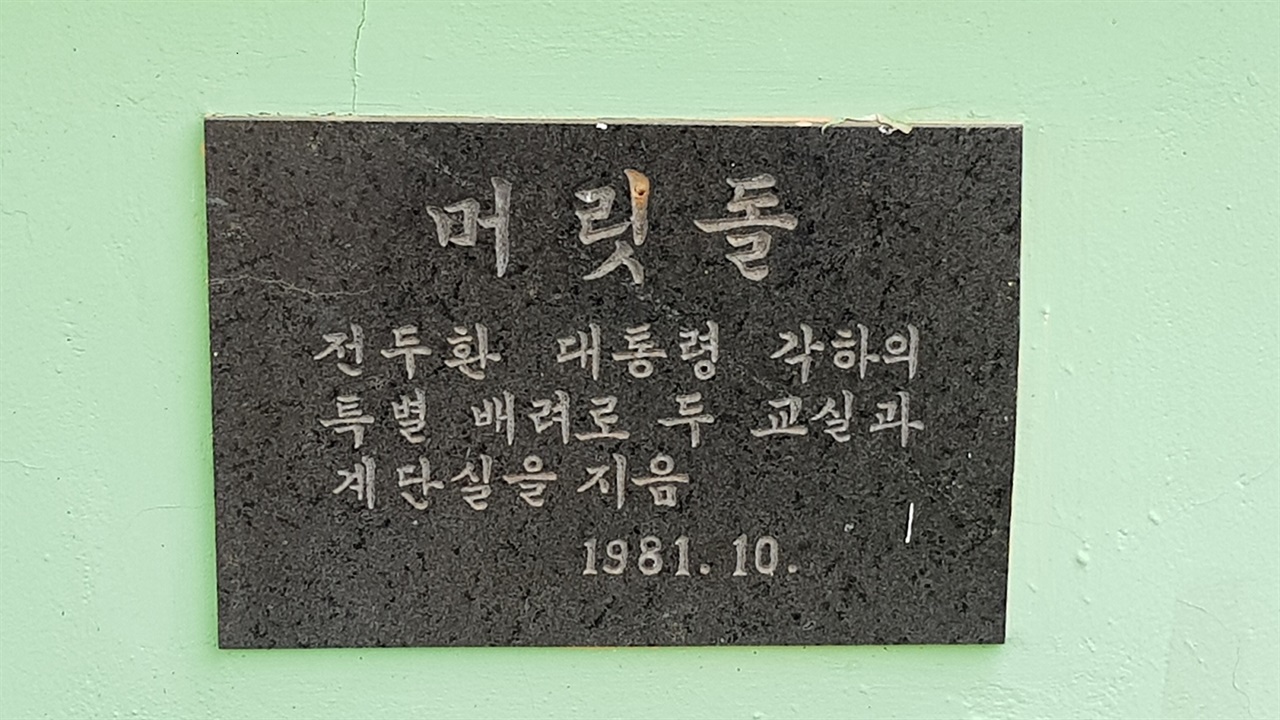 충남 예산군 신암면에 있는 조림초등학교 교사 1동에 붙은 전두환 머릿돌이다. 해당 학교는 회의를 통해 머릿돌 처리 문제를 결정할 예정이다. 