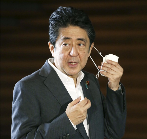 아베 신조 일본 총리가 지난 22일 오전 일본 총리관저에서 기자들의 질문에 답하기에 앞서 마스크를 벗고 있다.