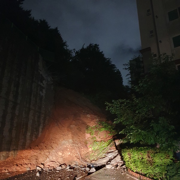 사진은 24일 오전 부산 금정구 한 아파트 인근에서 축대 붕괴로 20t 규모의 토사가 유출된 모습. 