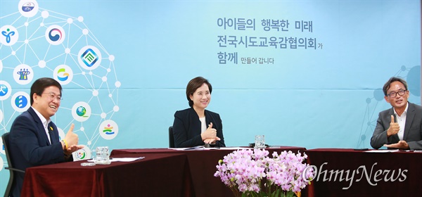 전국시도교육감협의회장인 최교진 세종시 교육감, 유은혜 부총리 겸 교육부장관, 오연호 오마이뉴스 대표기자가 인터뷰 중 코로나19 방역에 힘쓰는 의료진에게 존경의 뜻을 담은 '덕분에' 수어를 하고 있다.