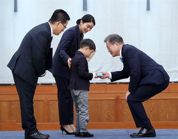 문재인 대통령이 29일 청와대에서 박지원 신임 국가정보원장에게 임명장을 수여한 뒤 박 원장의 손자에게 선물을 건네고 있다. 2020.7.29