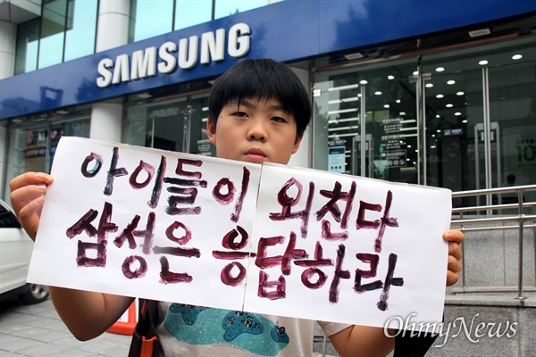 경남기후위기비상행동은 7월 29일 삼성전자서비스 마산센터 앞에서 기자회견을 열어 "삼성의 석탄화력발전 투자 중단되어야 한다"고 했고, 마산가포초등학교 박지호(6년)군이 손팻말을 들고 서 있다.