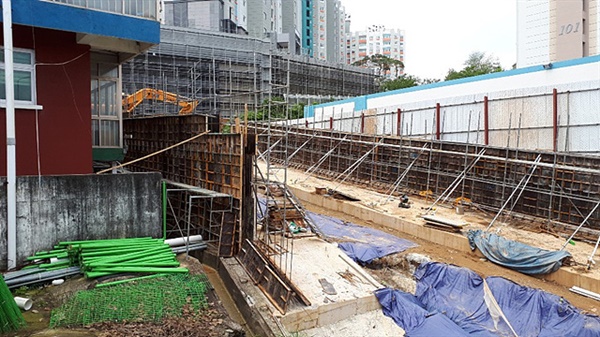 여수정보과학고등학교 3개동 인근으로 A아파트 진입로가 들어서고 있다. 학교 본관동 옹벽과 진입로 옹벽까지의 거리는 170센티미터이고 학교 본관 지면에서 3.2미터 높이까지 흙채우기 공사가 계획되어 학교 3개동은 지하화가 우려된다. 뒤편에 신축아파트가 보인다. 