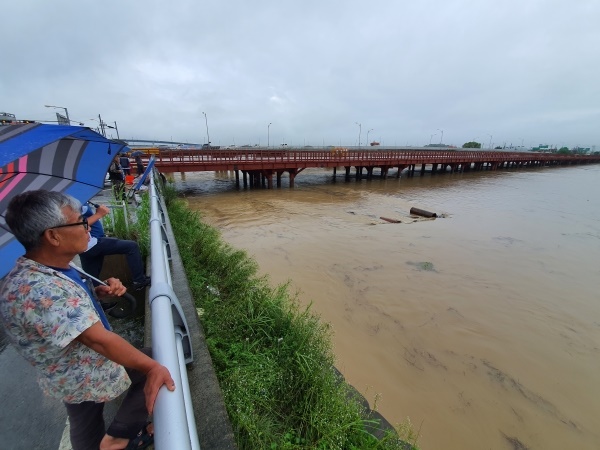 지난 30일 논산천에 홍수경보가 발령됐다. 시민들이 논산천에 나와 물어난 물을 바라보고 있다
