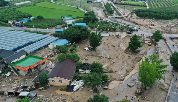 많은 비가 내려 2일 오전 둑 일부가 무너진 경기 이천시 산양저수지 부근 마을이 토사로 덮여 있다.