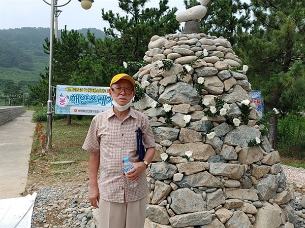 이야포 피난선 미군폭격사건 70주년 추모위원회가 건립한 평화탑 옆에선 이춘혁씨 모습. 돌탑 맨위의 새를 닮은 돌은 억울하게 희생된 이들의 넋이 하늘로 올라가기를 기원하는 의미다.    