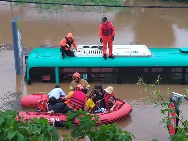  6일 오전 경기 파주시의 한 도로에서 시내버스가 물에 잠겨 구조 대원들이 승객들을 구조하고 있다. (파주소방서 제공)