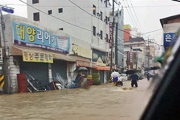 7일 광주 지역에 내린 폭우로 인해 곳곳이 침수된 모습. 허벅지까지 물이 찬 광주 서구 양동의 도로를 시민들이 지나고 있다. 