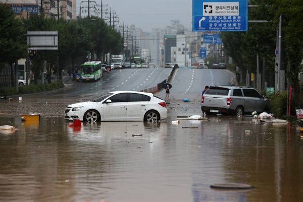  집중호우가 내린 8일 오전 광주 북구 신안교 부근 도로를 지나던 차량이 침수로 멈춰서 있다.