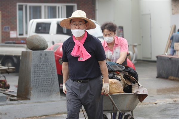  11일 오전 전남 구례군 문척면 구성마을에서 미래통합당 주호영 원내대표가 마을회관에 남아있는 침수 피해 폐기물을 옮기고 있다.