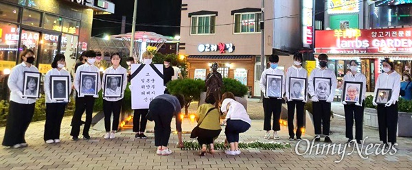 12일 저녁 창원마산 오동동 문화광장에서 열린 “일본군 위안부 피해자 추모문화제”. 참가자들이 인권자주평화다짐비 앞에서 헌화하고 있다.
