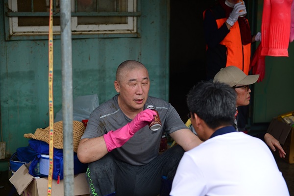 화엄사 주지 덕문 스님이 커피 한 캔으로 목을 축이는 가운데 자원봉사자들과 기자가 질문을 하고있다.