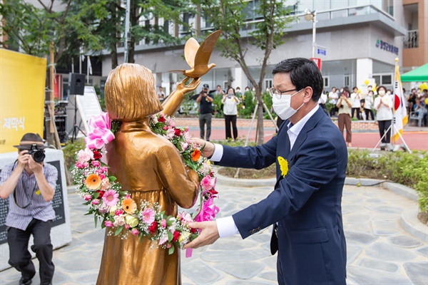 김돈곤 군수가 14일 청양평화의소녀상에 꽃 목걸이를 걸어주고 있다.