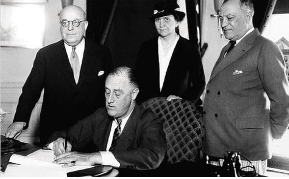 1935년 7월 5일 미국 역사상 최초의 여성 장관인 프란시스 퍼킨스 노동부장관이 지켜보는 가운데 전국노동관계법에 서명하는 프랭클린 루즈벨트 대통령. 