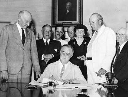 1935년 8월 14일 사회보장법에 서명하는 프랭클린 루즈벨트 대통령 뒤로 사회보장법을 주도한 프란시스 퍼킨스 노동부장관이 서 있다. 