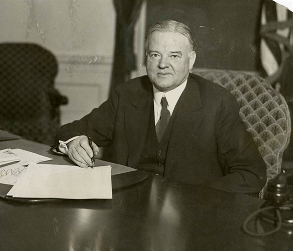 1930년 12월 20일 워싱턴 백악관 집무실에서 실업부조법에 서명하는 후버 대통령.
